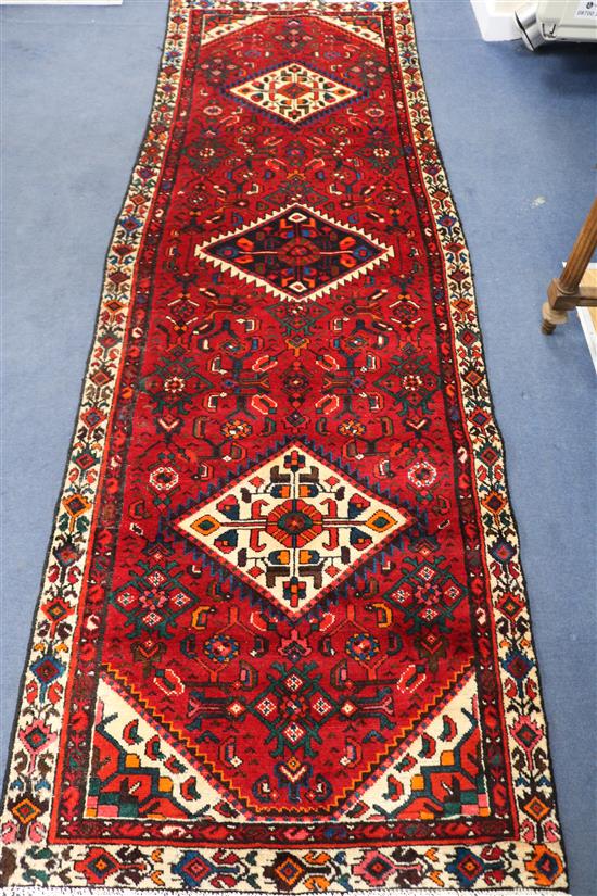 A Hamadan red ground rug, 288cm x 96cm